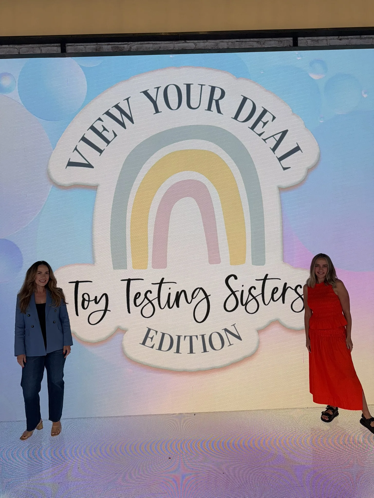 The View's studio screen reading View Your Deal, Toy Testing Sisters Edition, with Mandy and Mel on stage