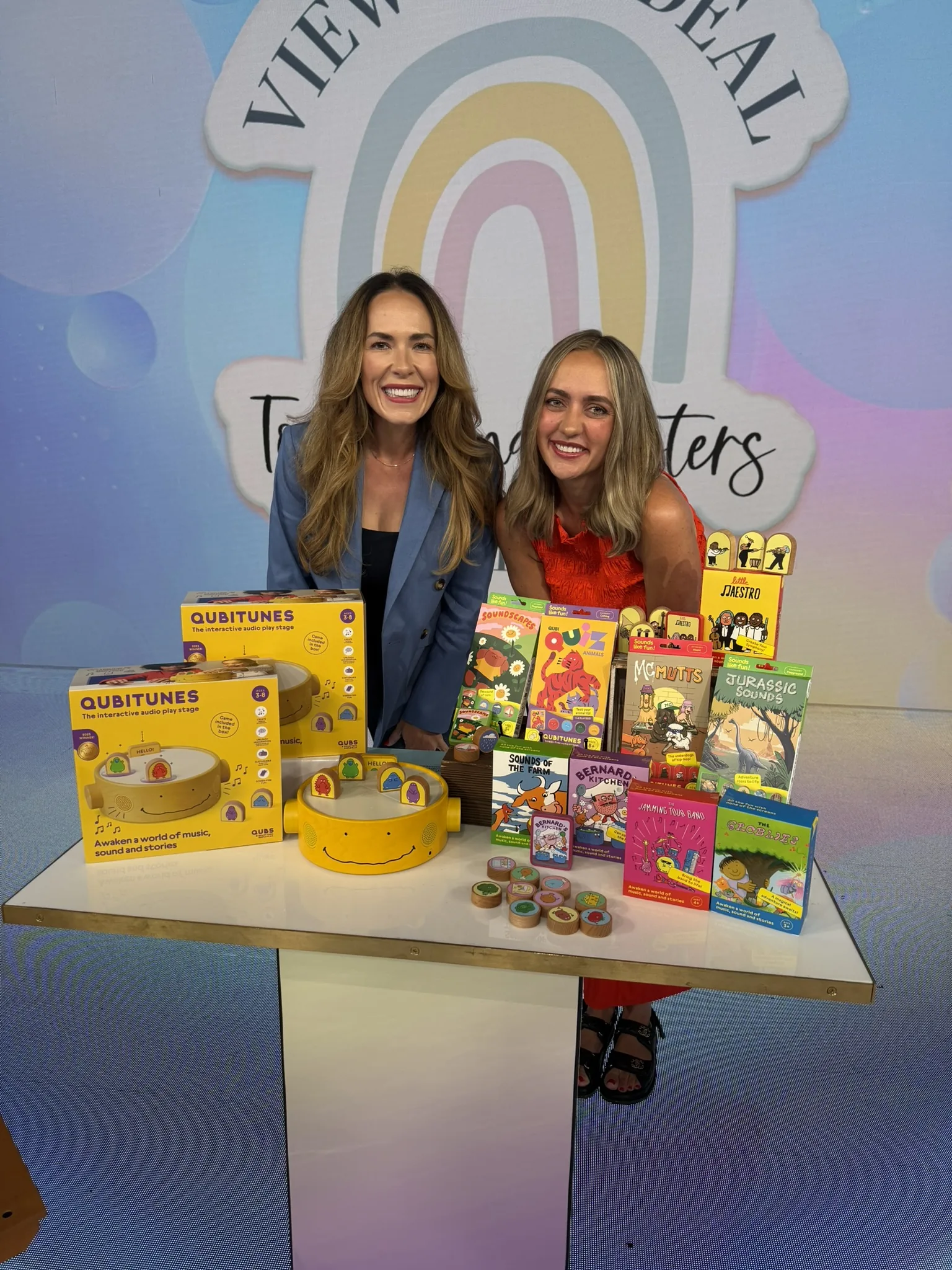 Mandy and Mel behind a table of toys on the set of The View