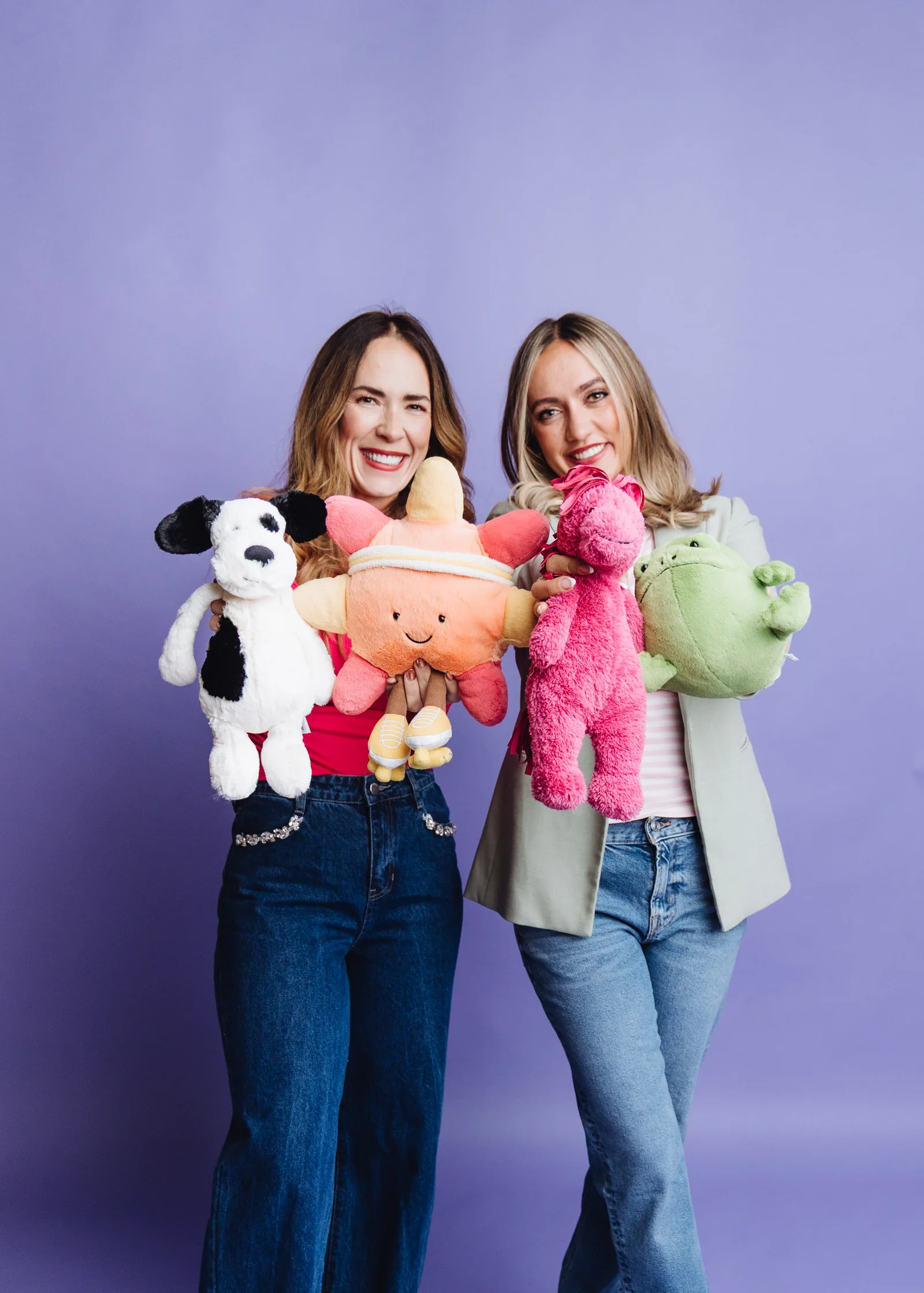 Mandy and Mel holding a pile of plush toys